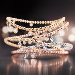 Capolavoro Prosecco Armbaender in Gelb-, ROse- und Weissgold mit Diamantanhängern auf grauem Hintergrund