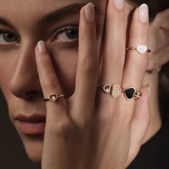 Weibliches Modell traegt mehrere Happy Hearts Ringe von Chopard an einer Hand