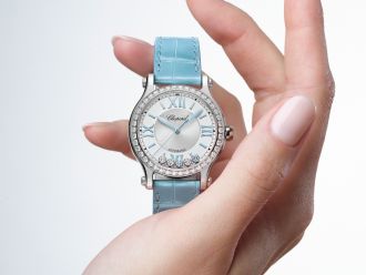 Chopard Happy Sport Uhr in Stahl mit Diamantluenette und hellblauem Lederarmband auf einer Damenhand stehend