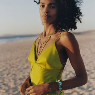 Weibliches Model vor Strandkulisse traegt ein Armband und Collier aus der Mikado Kollektion von Tamara Comolli