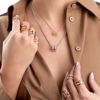 Weibliches Model traegt Ringe und zwei Halsketten mit Anhaenger aus der Ice Cube Kollektion von Chopard