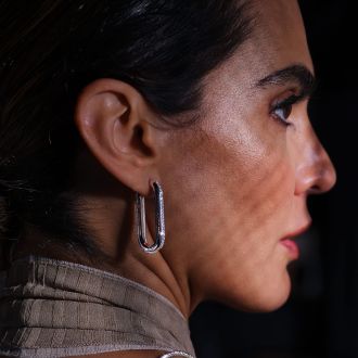 Weibliches Model im Profil mit einer Creole in Weissgold und Diamanten