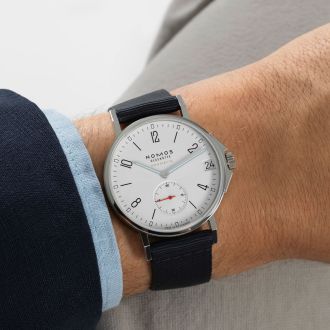 Handgelenk mit NOMOS Glashütte Ahoi Uhr – elegantes neues Ahoi Modell mit weißem Zifferblatt und Textilarmband