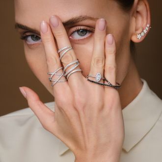 Mehrere moderne Ringe aus Weißgold und Gold mit Diamanten, stilvoll an einer Hand getragen, Nahaufnahme.