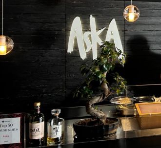 Innenansicht des Restaurants Aska in Regensburg mit beleuchtetem Logo, Barbereich und stilvollem Ambiente – Partnerrestaurant für den Genussgutschein von Juwelier Mühlbacher.