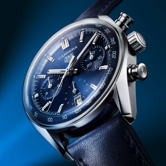 TAG Heuer Carrera Chronograph in Stahl mit blauem Zifferblatt und blauem Lederarmband vor dunkelblauem Hintergrund