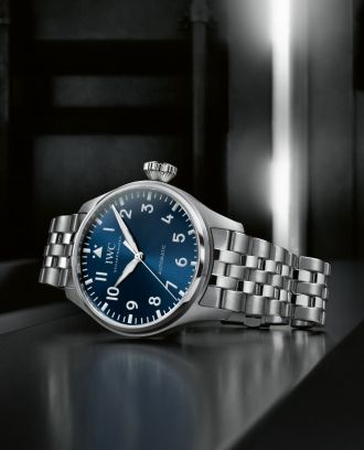 IWC Schaffhausen Pliot's Watch in Stahl mit blauem Zifferblatt seitlich auf schwarz-grauem Untergrund liegend