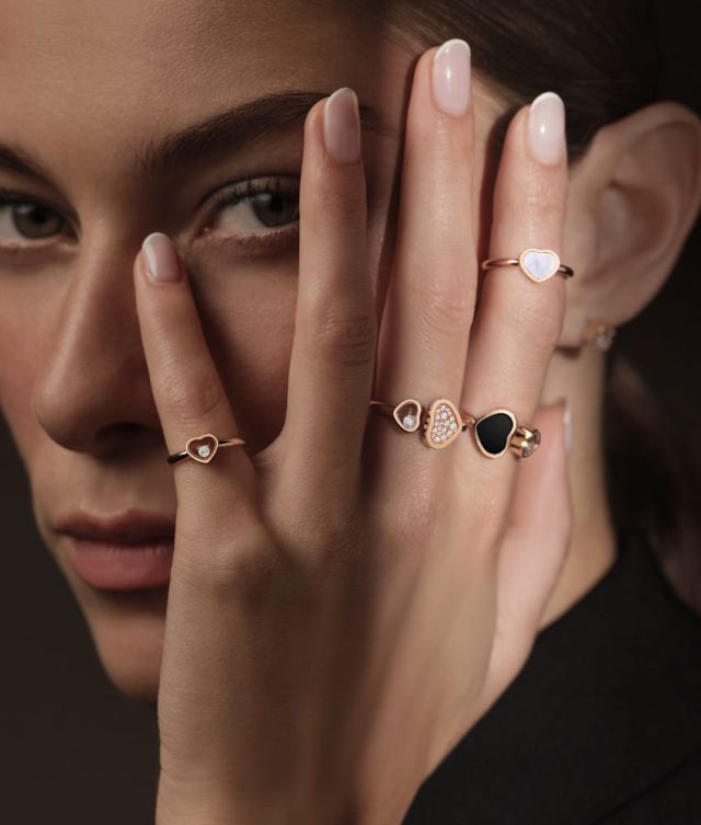 Chopard Happy Hearts Ringe in Rosegold mit verschiedenen Farbsteinen in Herzform und Diamanten von einem Model getragen