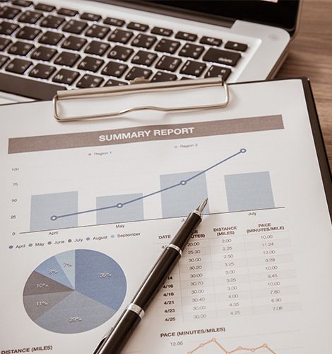 Arbeitsplatz im Büro mit Laptop, Klemmbrett und Berichten