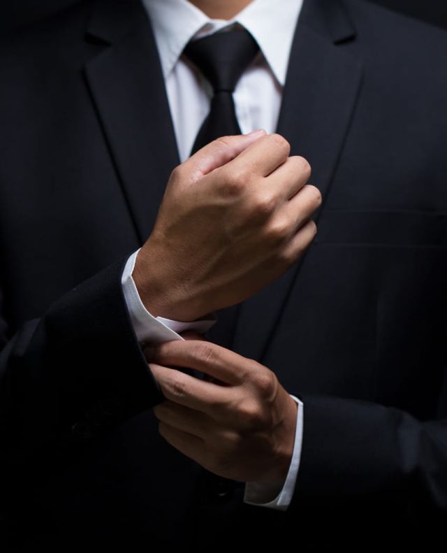 Braeutigam im Anzug macht sich seine Hemdsaermel zu