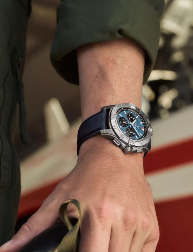 Breitling Avenger Chronograph in Stahl mit blauem Zifferblatt, schwarzen Totalisatoren und blauem Textilarmband am Handgelenk getragen