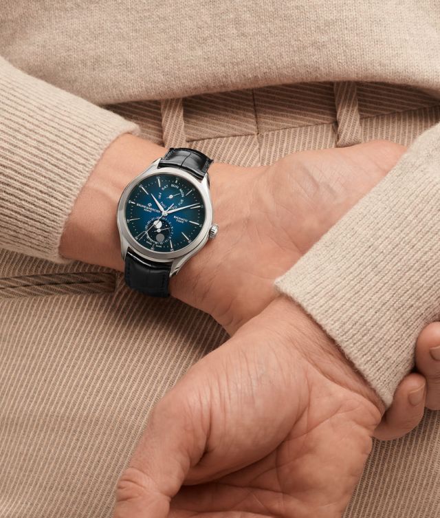 Maennliches Model mit am Ruecken verschränkten Armen traegt eine Clifton Uhr in Stahl mit blauem Zifferblatt und schwarzem Lederarmband