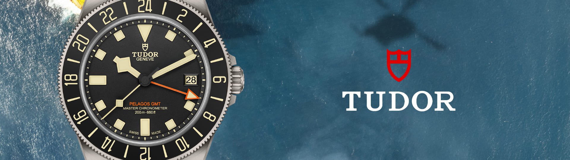 TUDOR Pelagos FXD GMT Uhr in Titan mit schwarzer Luenette und Zifferblatt auf Wasserhintergrund mit TUDOR Logo