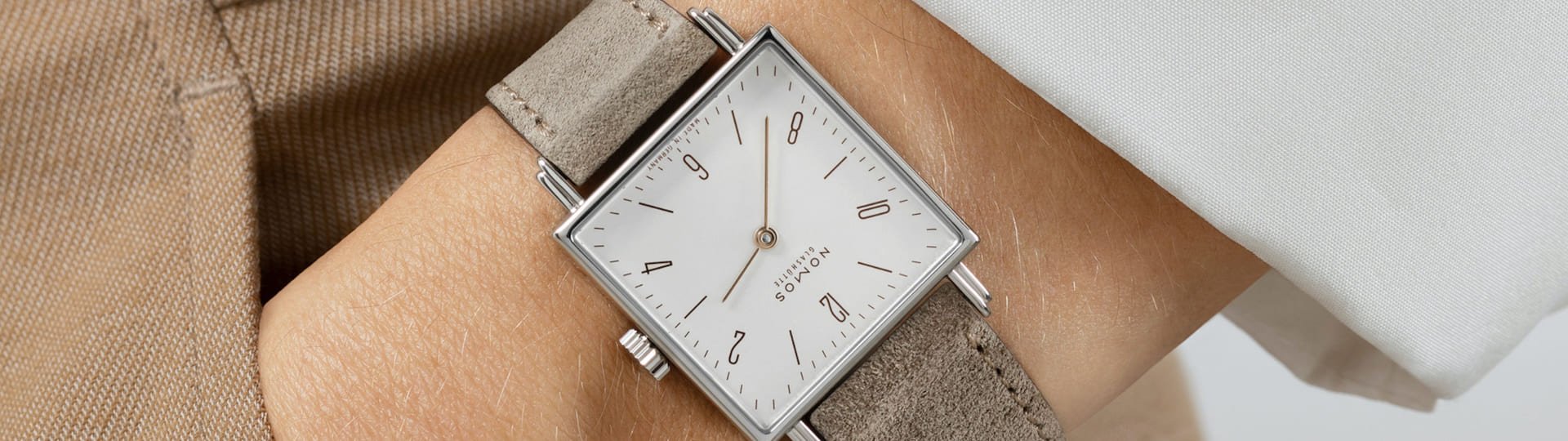 Damenhandgelenk mit Tetra Uhr von NOMOS Glashuette in Stahl mit weissem Zifferblatt und taupefarbenem Lederarmband