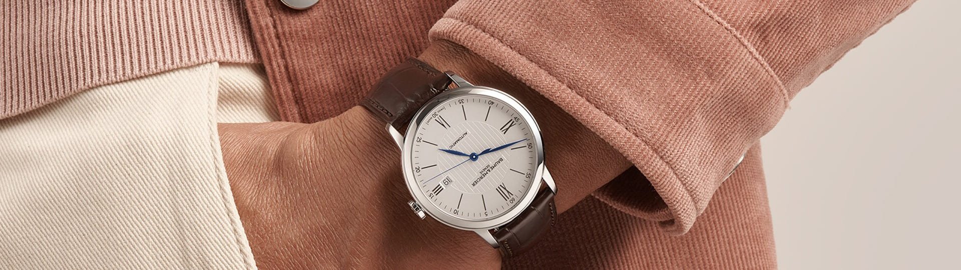 Baume Mercier Classima Uhr in Stahl mit weissem Zifferblatt und braunem Lederarmband an einem Herrenhandgelenk getragen