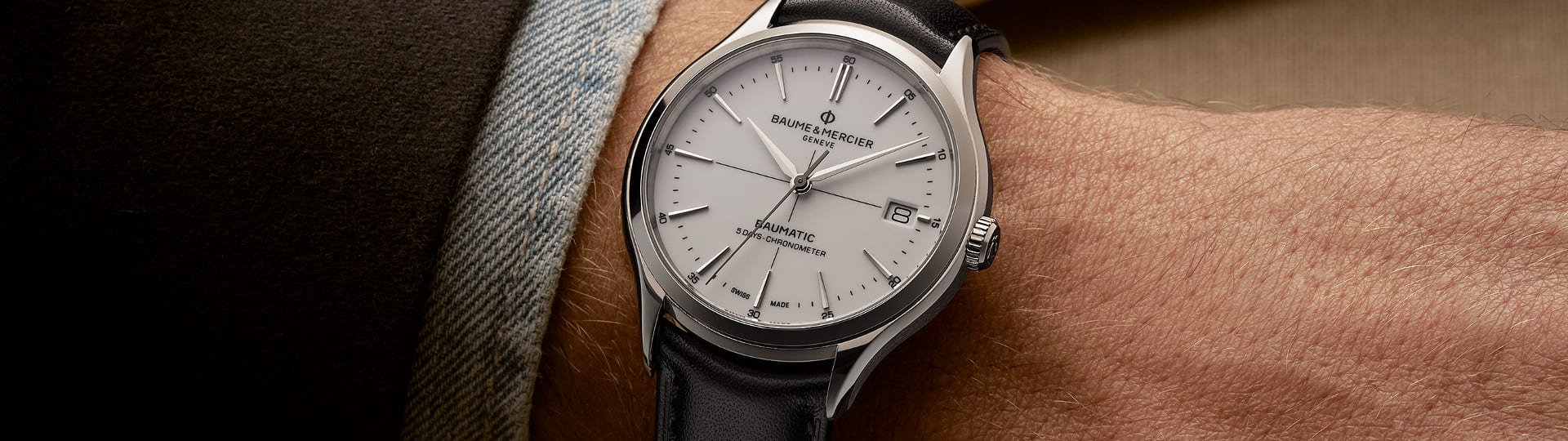 Herrenhandgelenk mit einer Baume & Mercier Clifton Baumatic Uhr in Stahlmit weissem Zifferblatt und Lederarmband