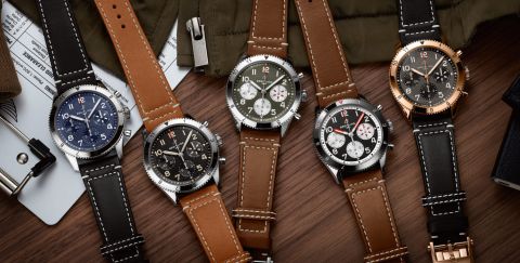 Fünf Classic AVI Chronographen von Breitling auf Holzhintergrund liegend