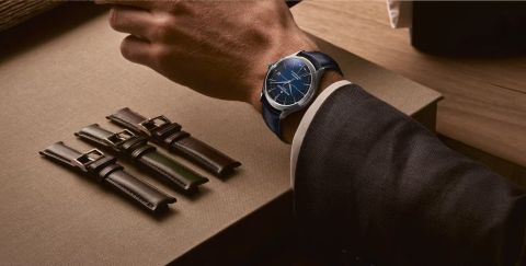 Clifton Baumatic Herrenuhr in Stahl mit blauem Zifferblatt und Lederarmband getragen an einem Herrenhandgelenk, drei Lederarmbaender zu Austauschen liegen daneben