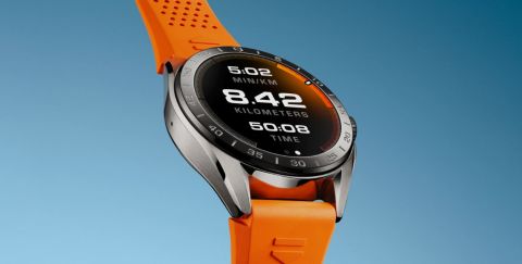 TAG Heuer Connected Smartwatch in Stahl mit Displayzifferblatt und orangefarbenem Kautschukband vor blauem Hintergrund