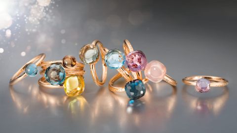 Mehrere Ringe aus der Happy Holi Kollektion con Capolavoro in Rosegold mit verschiedenen Farbedelsteinen auf grauem Hintergrund Mehrere Ringe aus der Happy Holi Kollektion con Capolavoro in Rosegold mit verschiedenen Farbedelsteinen auf grauem Hintergrund