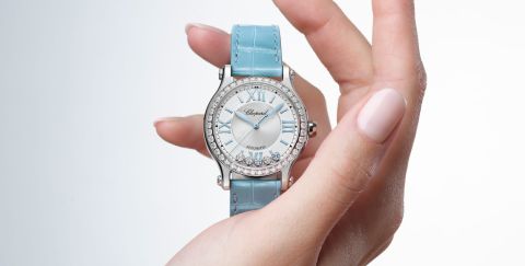 Chopard Happy Sport Damenuhr mit Gehaeuse in Stahl mit Diamantluenette, silbernem Zifferblatt mit 5 beweglichen Diamanten und hellblauem Lederarmband stehend auf einer Hand