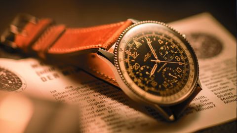 Breitlings ikonische Navitimer Cosmonaute Referenz 809 von 1962 mit braunem Lederarmband auf Flugunterlagen liegend