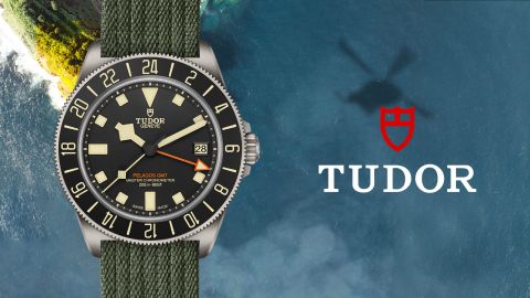 TUDOR Pelagos FXD GMT Uhr in Titan mit schwarzer Luenette und Zifferblatt auf Wasserhintergrund mit TUDOR Logo