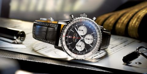 Breitling Navitimer Chronograph in Stahl mit schwarzem Zifferblatt und schwarzem Lederarmband seitlich auf Flugunterlagen liegend