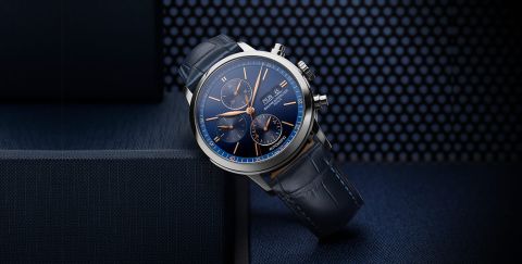 Classima Chronograph in Stahl mit blauem Zifferblatt und Lederarmband vor blauem Hintergrund