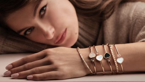 Weibliches Model mit 4 Happ Hearts Armreifen und 2 Ice Cube Armbaender jeweils in Rosegold im Layering Look an einem Arm