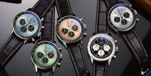 Fuenf Breitling Navitimer Chronographen mit Stahlgehaeuse, unterschiedlich farbigen Zifferblaetter und schwarzen Lederarmbaender auf Lifestylehintergrund