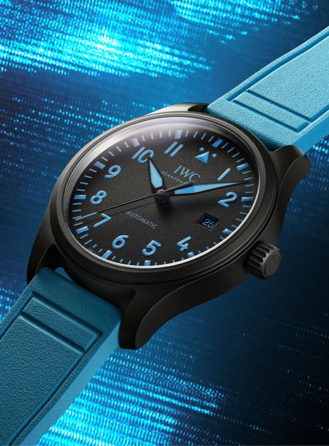 IWC Pilot’s Watch George Russell mit schwarzem Gehäuse, blauem Kautschukarmband und Datumsanzeige vor blauem Hintergrund IWC Pilot’s Watch George Russell mit schwarzem Gehäuse, blauem Kautschukarmband und Datumsanzeige vor blauem Hintergrund