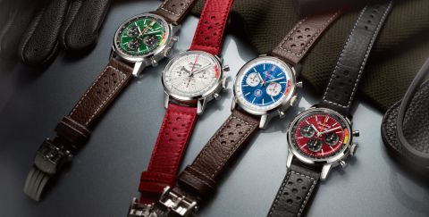 Vier Breitling Top Time Chronographen mit Stahlgehaeusen, unterschiedlich farbigen Zifferblaettern, gruen, weiss, blau und rot und Lederarmbaender liegend auf Lifestylehintergrund