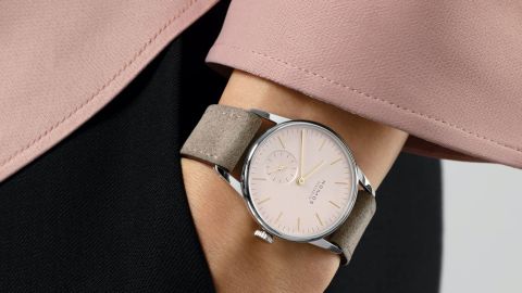 Weibliches Model mit NOMOS Glashuette Uhr in Stahl mit rosefarbenem Zifferblatt und Lederarmband am Handgelenk