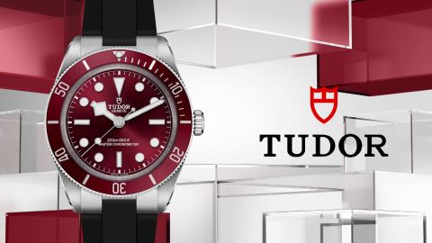 Links Tudor Black Bay 54 Uhr in Stahl mit roter Luenette und Zifferblatt, rechts daneben TUDOR Logo vor rot-grauem Lifestylehintergrund Links Tudor Black Bay 54 Uhr in Stahl mit roter Luenette und Zifferblatt, rechts daneben TUDOR Logo vor rot-grauem Lifestylehintergrund